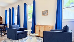 A living room with two dark blue sofas, a small white table, and a patterned rug.