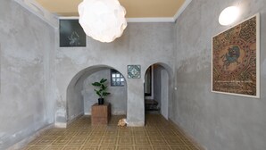 A hallway with a patterned floor, two wooden columns, a potted plant, and a framed artwork on the wall. - Ci' Capo 2 by Wonderful Italy (Palermo)