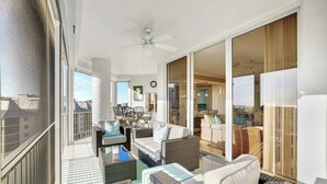 A balcony with wicker furniture, a ceiling fan, and a view of the city. - Regatta - WALK TO THE BEACH (Naples)