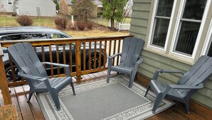 A wooden deck with Adirondack chairs and a patterned rug. - 4-bedroom house in adorable Clear Lake with AC, WiFi. Enjoy your stay (Clear Lake)