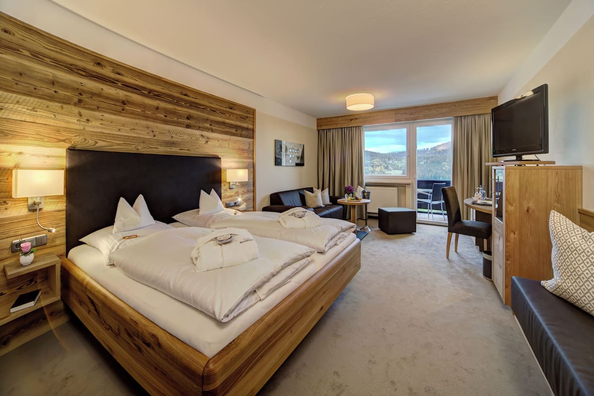 Une chambre d’hôtel avec un grand lit, un bureau, une chaise, une télévision et une vue sur l’extérieur.