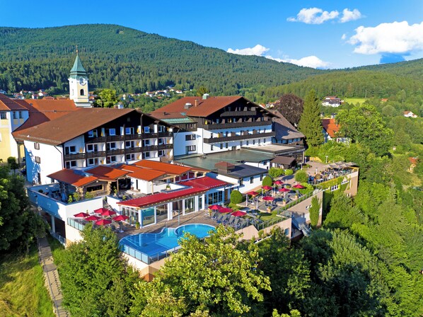 Un hôtel composé de plusieurs bâtiments, doté d’une piscine et situé au pied d’une montagne.