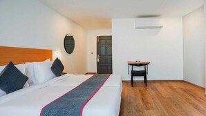Een hotelkamer met een bed, een klein tafeltje en een deur.