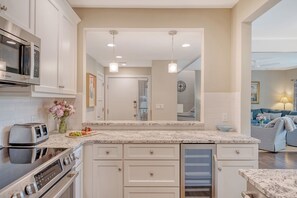 A modern kitchen with white cabinetry, a built-in microwave, a toaster, and a sink.