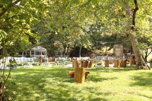 A garden with wooden benches, a gazebo, and a stone wall.