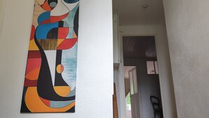Una scala con gradini in legno e un quadro astratto appeso al muro.