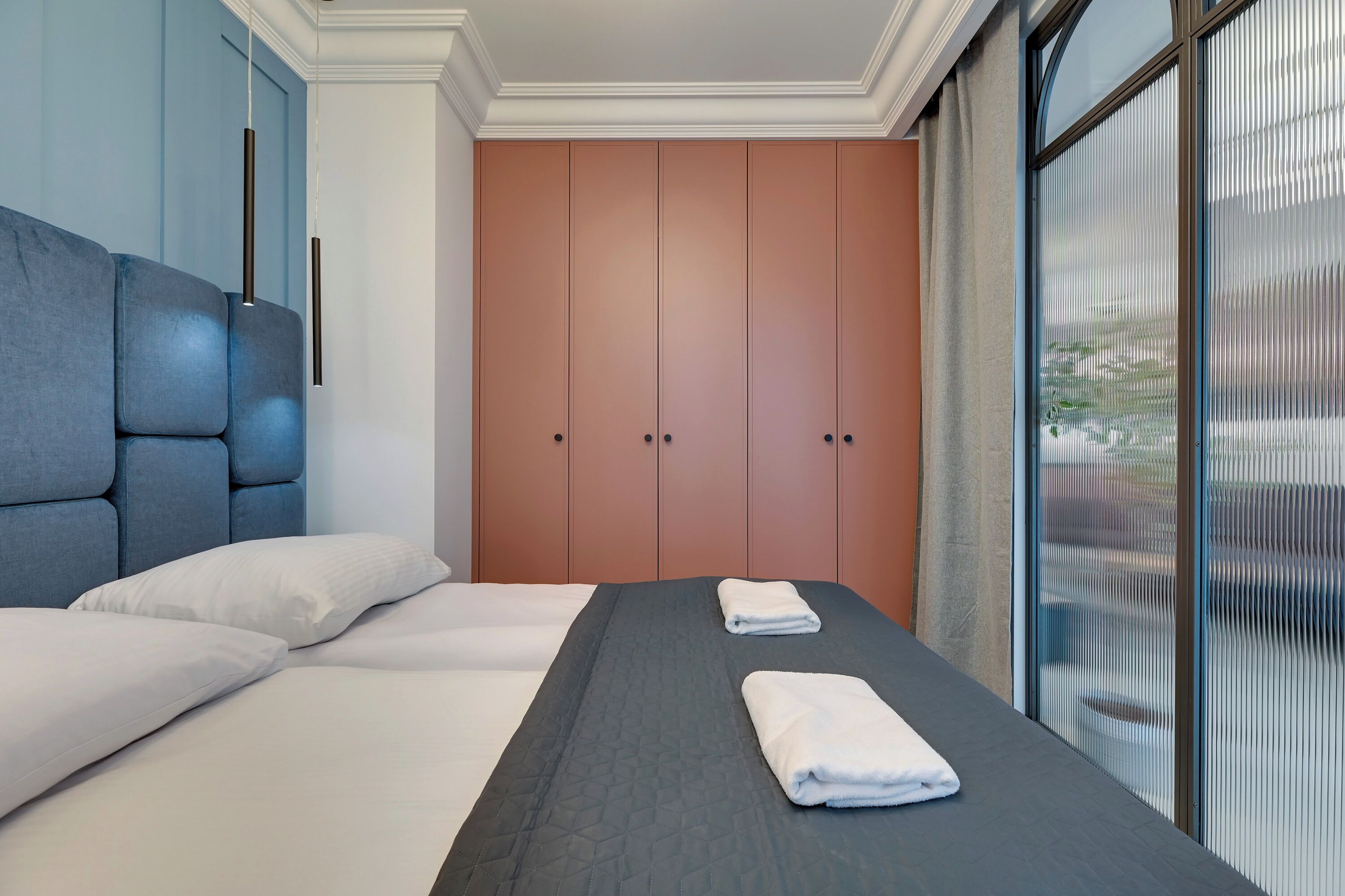 Ein Hotelzimmer mit einem großen Bett, einem Kleiderschrank und einem Fenster mit Jalousien.