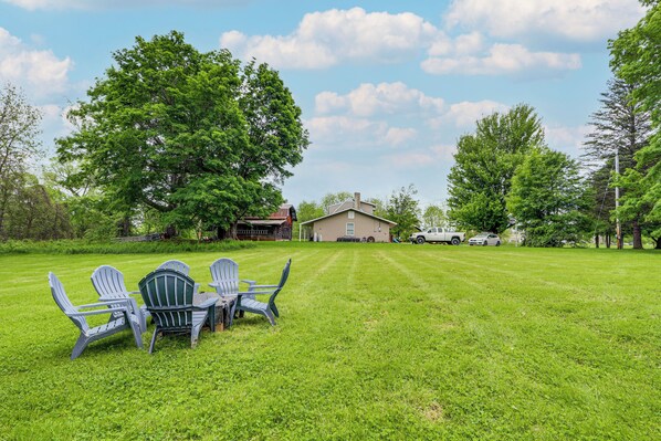 A grassy lawn with a table and chairs, a house, and a truck in the background. - 11 Mi to Oneida Lake: Spacious Apt in Verona! (Verona)