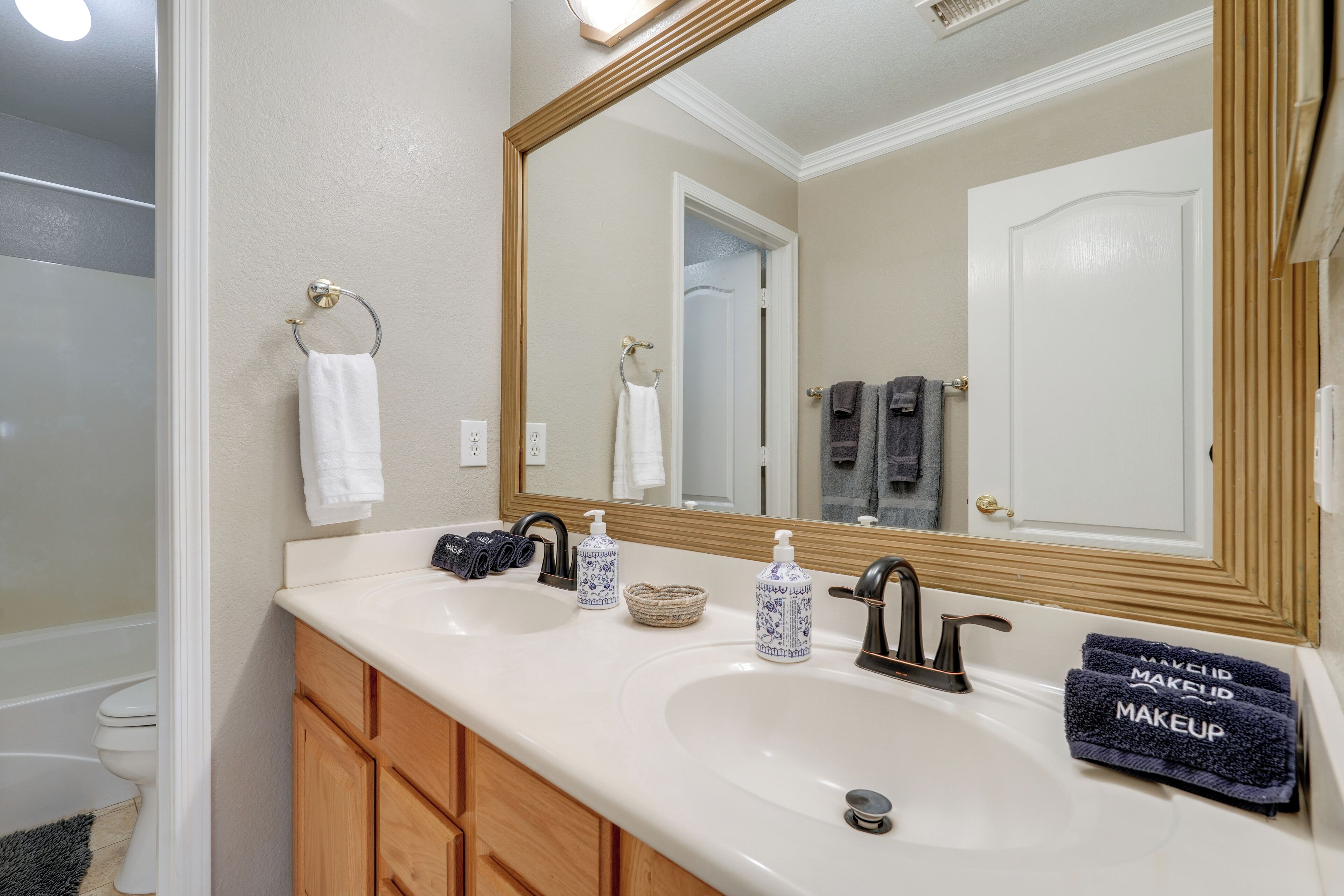 Une salle de bain avec deux lavabos, un miroir et un porte-serviettes.