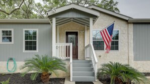 A two-story house with a front porch, a flag, and two palm trees. - Family-friendly Rock Island Home 5 Mi to Splashway (Rock Island)
