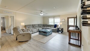 A spacious living room with a sectional sofa, a coffee table, and a TV on a wooden stand. - Family-friendly Rock Island Home 5 Mi to Splashway (Rock Island)