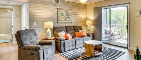 A modern living room with a sofa, armchair, and a round coffee table.