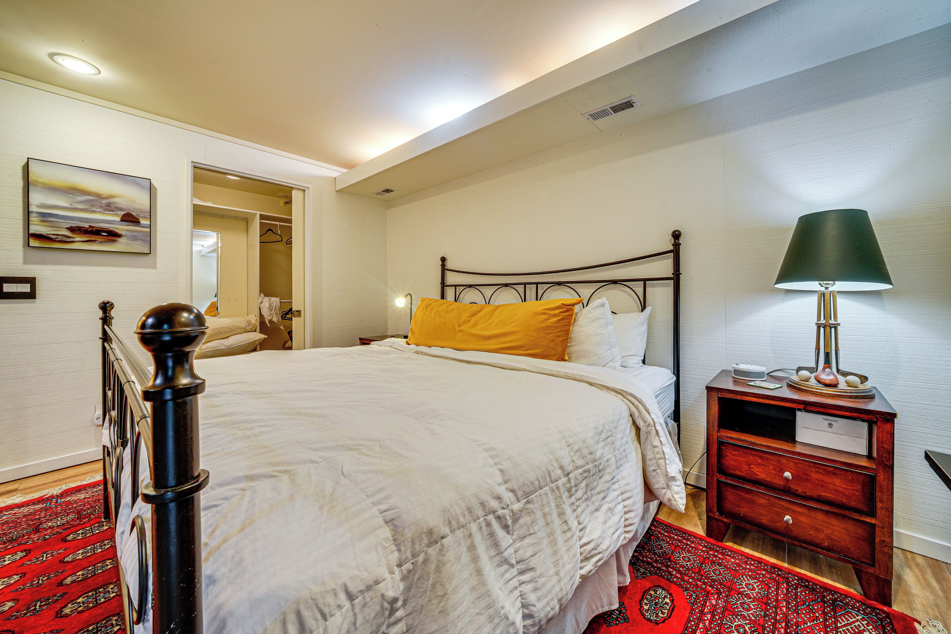 Une chambre bien rangée, avec un lit, une table de chevet et une lampe.
