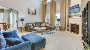 Un salon spacieux avec un grand canapé, une table basse et une cheminée.
