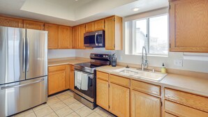 A modern kitchen with wooden cabinets, stainless steel appliances, and a skylight. - Pool Access & Mtn Views: Lake Havasu City Condo! (Lake Havasu City)