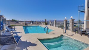 A swimming pool with lounge chairs and a view of mountains. - Pool Access & Mtn Views: Lake Havasu City Condo! (Lake Havasu City)