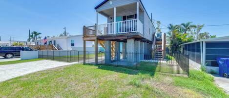 A two-story house with a balcony, a fenced yard, and a garage.