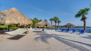 A beach with thatched umbrellas, blue lounge chairs, and a sandy walkway. - Bahama BAY Resort Near Disney! 3BR 2BA + Kitchen! (Davenport)