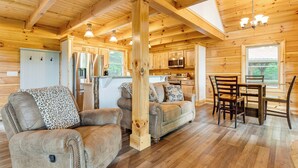 A log cabin interior with a living room, dining area, and kitchen. - Waynesville Romantic Hideaway w/ Private Hot Tub (Waynesville)