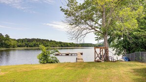 Une terrasse au bord du lac, dotée d’une structure en bois, d’un quai et d’une zone délimitée par une clôture.