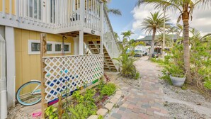 A yellow building with a white balcony and a paved walkway. - Walk to Beach: Fort Meyers Home w/ Patio! (Fort Myers Beach)