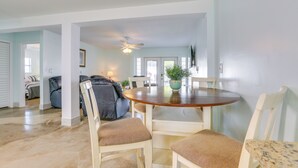 A dining area with a round table, four chairs, and a ceiling fan. - Walk to Beach: Fort Meyers Home w/ Patio! (Fort Myers Beach)