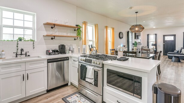 A modern kitchen with white cabinets, stainless steel appliances, and a central island. - < 1 Mi to Beaches: Galveston Retreat w/ Patio! (Galveston)