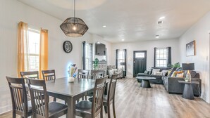A spacious living area with a dining table, chairs, a sofa, and a coffee table. - < 1 Mi to Beaches: Galveston Retreat w/ Patio! (Galveston)