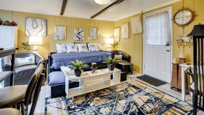A cozy living room with a bed, sofa, coffee table, and artwork on the walls. - 1 Mi to Dtwn: Fayetteville Studio w/ Patio (Fayetteville)