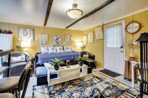 A cozy living room with a bed, sofa, coffee table, and artwork on the walls. - 1 Mi to Dtwn: Fayetteville Studio w/ Patio (Fayetteville)