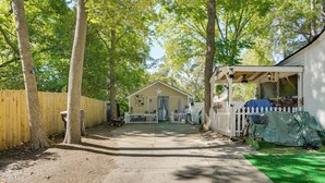 A wooden pathway leading to a small building with a star on the roof, surrounded by trees and a white picket fence. - 1 Mi to Dtwn: Fayetteville Studio w/ Patio (Fayetteville)