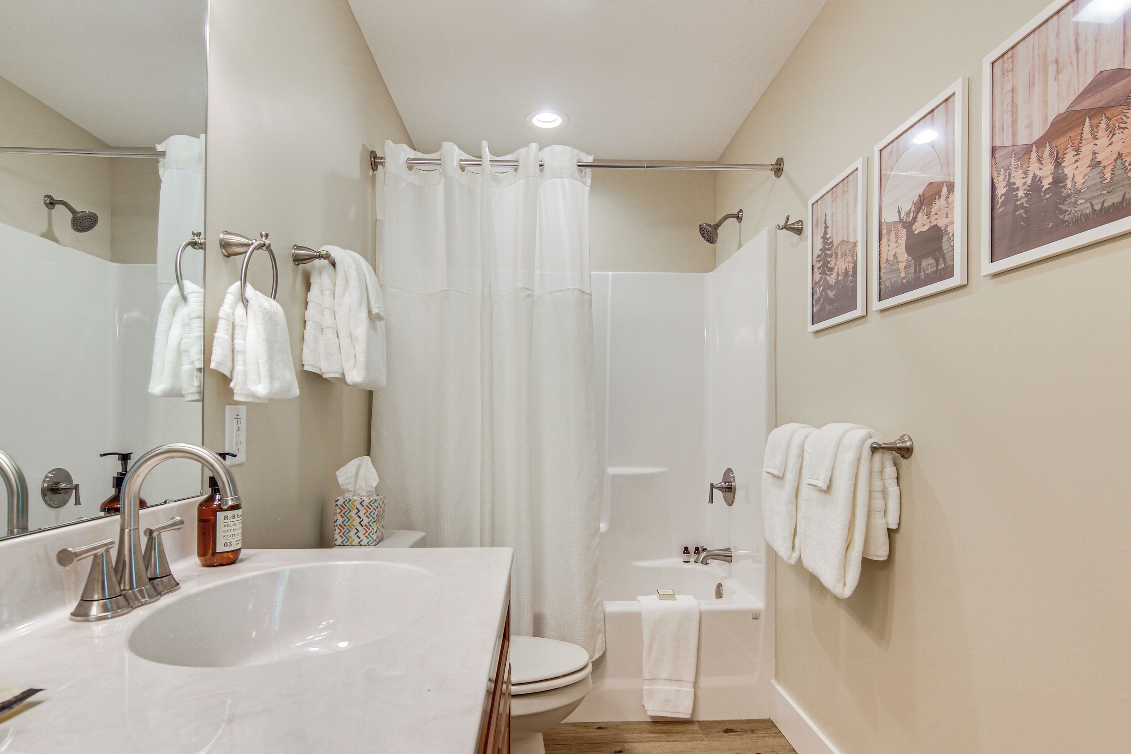 A bathroom with a large sink, toilet, and shower area.
