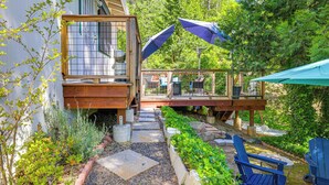 A wooden deck with outdoor furniture and a glass enclosure.