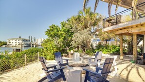 Une terrasse au bord de la plage, avec un foyer et des chaises longues.