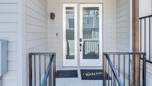 A white house with a wooden porch and a double door with a glass panel. - Skyline Views: Nashville Townhome 3 Mi to Broadway (Nashville)