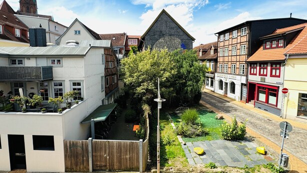 Eine schmale Straße mit traditioneller europäischer Architektur, darunter Fachwerkhäuser und ein Kirchturm.