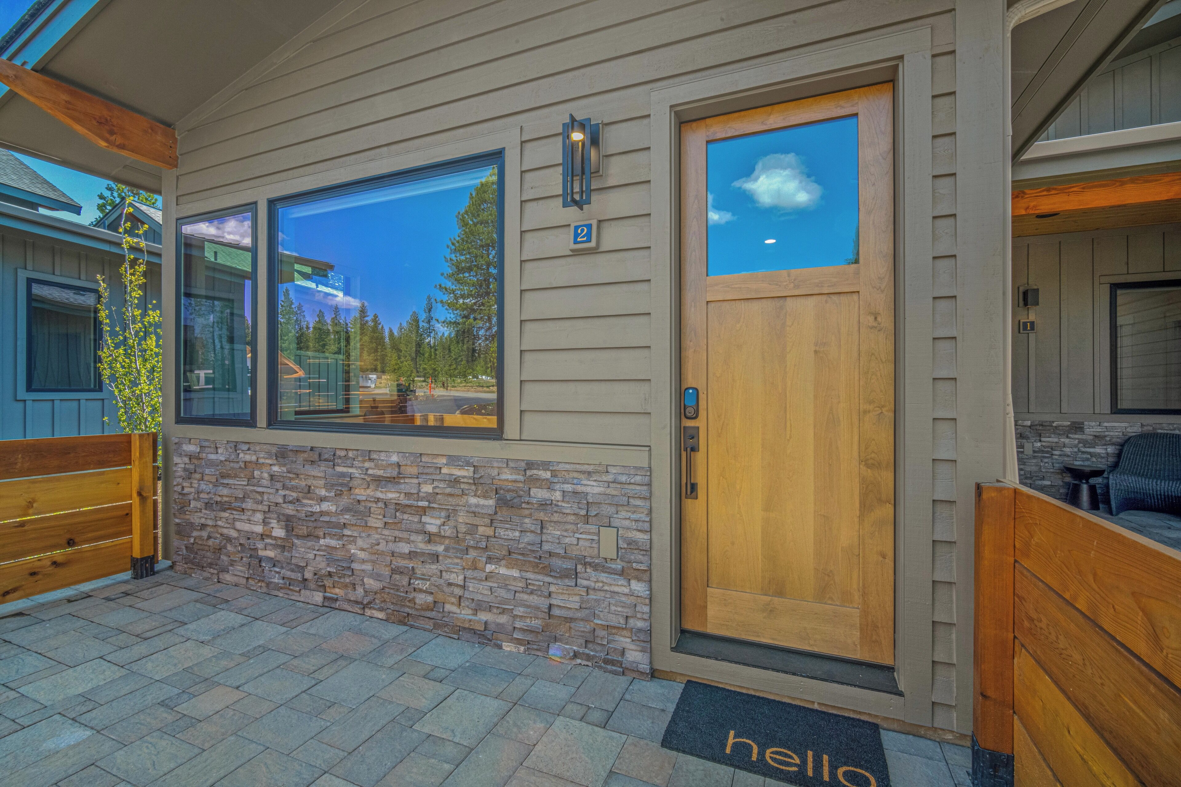 A modern house with a stone facade, large windows, and a wooden door.