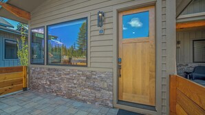 A modern house with a stone facade, large windows, and a wooden door. - Designer Forest Studio with Access to Forest House (Sunriver)
