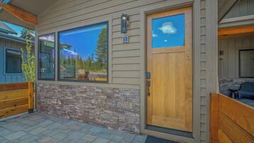 A modern house with a stone facade, large windows, and a wooden door.