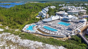 Vista aérea de un resort con múltiples piscinas, un gran complejo de edificios y zonas boscosas circundantes.