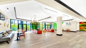 A spacious lobby with a high ceiling, large windows, and a mix of seating areas including sofas and tables. - Modern 2BR Condo w Private Patio7 min to Disney (Winter Garden)