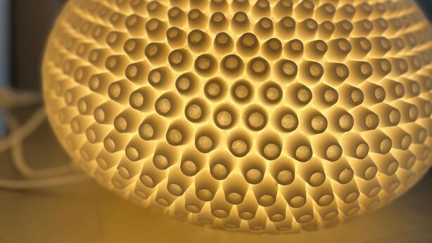 Un objeto esférico con textura y un patrón de puntos en relieve, posiblemente un adorno o un mueble.