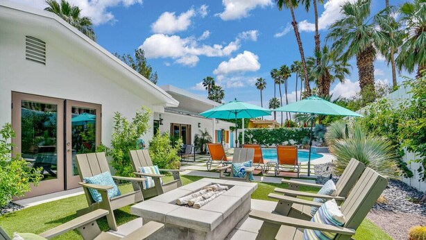 A modern outdoor patio with lounge chairs, a fire pit, and a pool area. - The Cove: Heated Pool, BBQ, Walk To Downtown PS (Palm Springs)