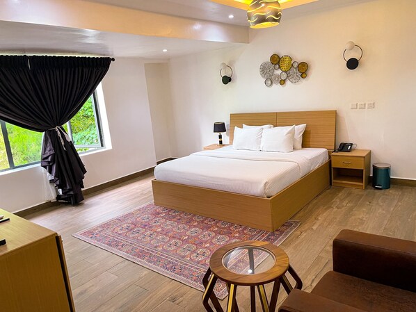 A modern bedroom with a wooden bed, bedside tables, a small round table, and a patterned rug.