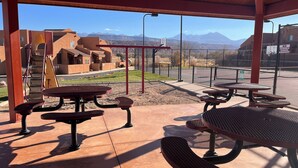 An outdoor patio area with picnic tables and a playground. - 17A3 Two Master Suites, Views, Community Pool & Hot Tub (Moab)
