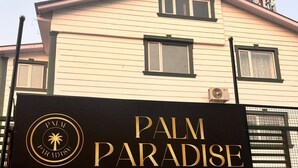 Señalización para 'Palm Paradise' con un logotipo de palmera, indicando un hotel o resort.