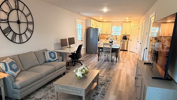A modern living room with a sofa, coffee table, and a large wall clock.
