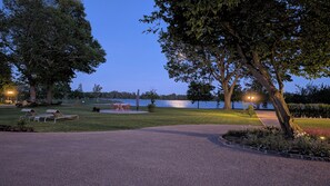 A park with a lake, outdoor seating, and a well-maintained lawn.