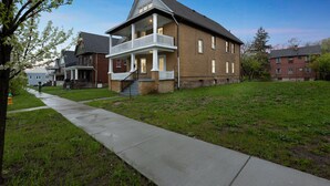 A two-story house with a front porch and a small staircase leading to the entrance. - Comfy 3br Flat Close To The Falls 3 Bedroom Apts (Niagara Falls)