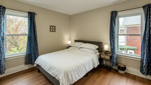 A bedroom with a bed, nightstands, and curtains. - Cozy Upper Flat Minutes From Niagara Falls 3 Bedroom Apts (Niagara Falls)